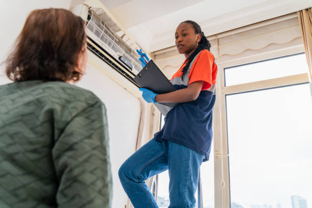 black female Service worker explaining female customer how to use air conditioner